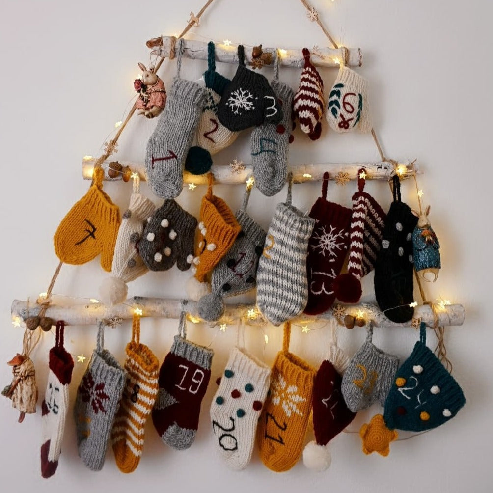 A wall decorated with multiple handcrafted Christmas stockings, hats, and mittens.