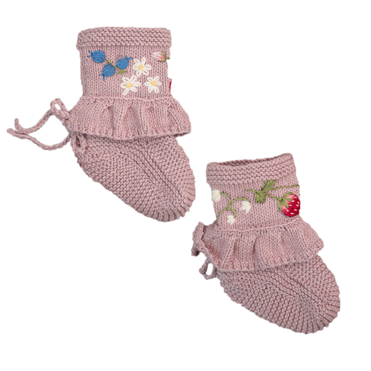 Pink knitted baby booties with ruffle trim and floral embroidery.