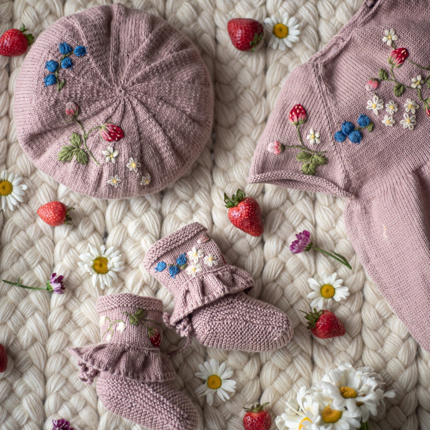 Coordinated set of pink embroidered knitwear with booties, beret, and top.