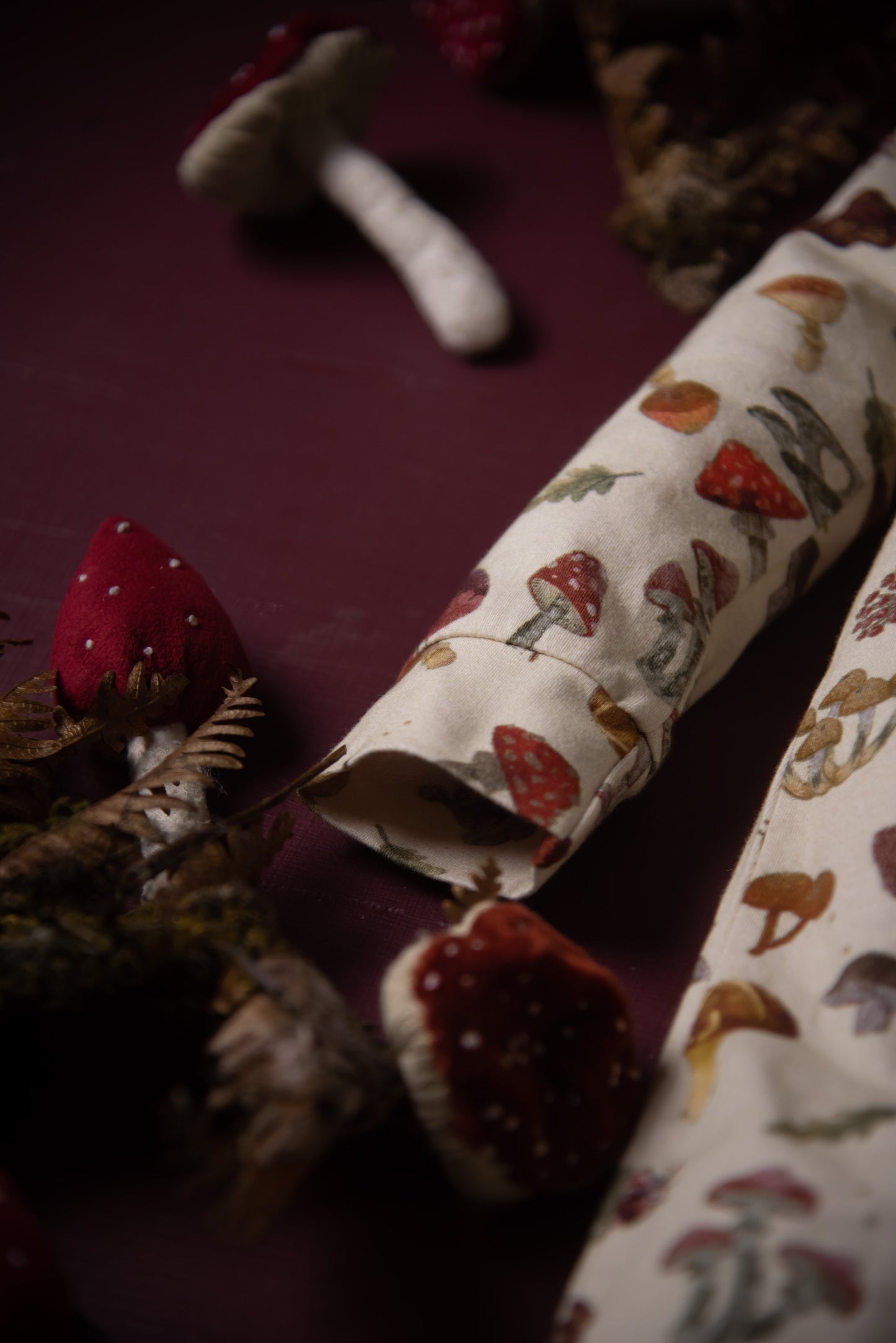 A close-up of the romper’s sleeve shows the detailed mushroom print alongside decorative fabric mushrooms.