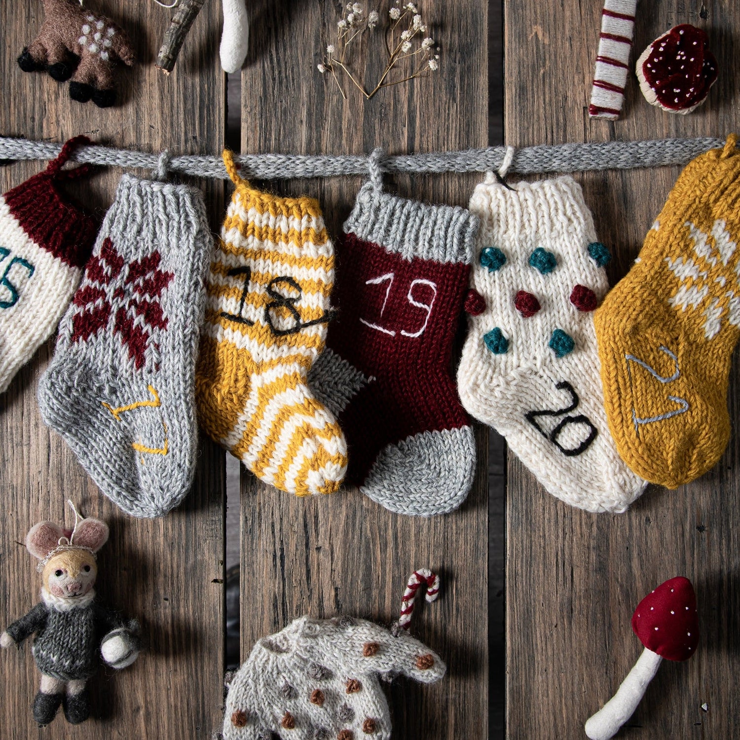 Handcrafted mittens and socks from the multicolor Advent Calendar displayed on a table with festive decorations.