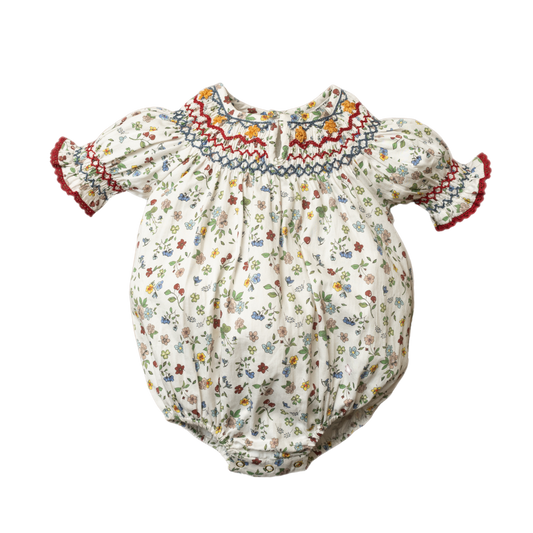 White baby romper with colorful floral print and red embroidered smock neckline