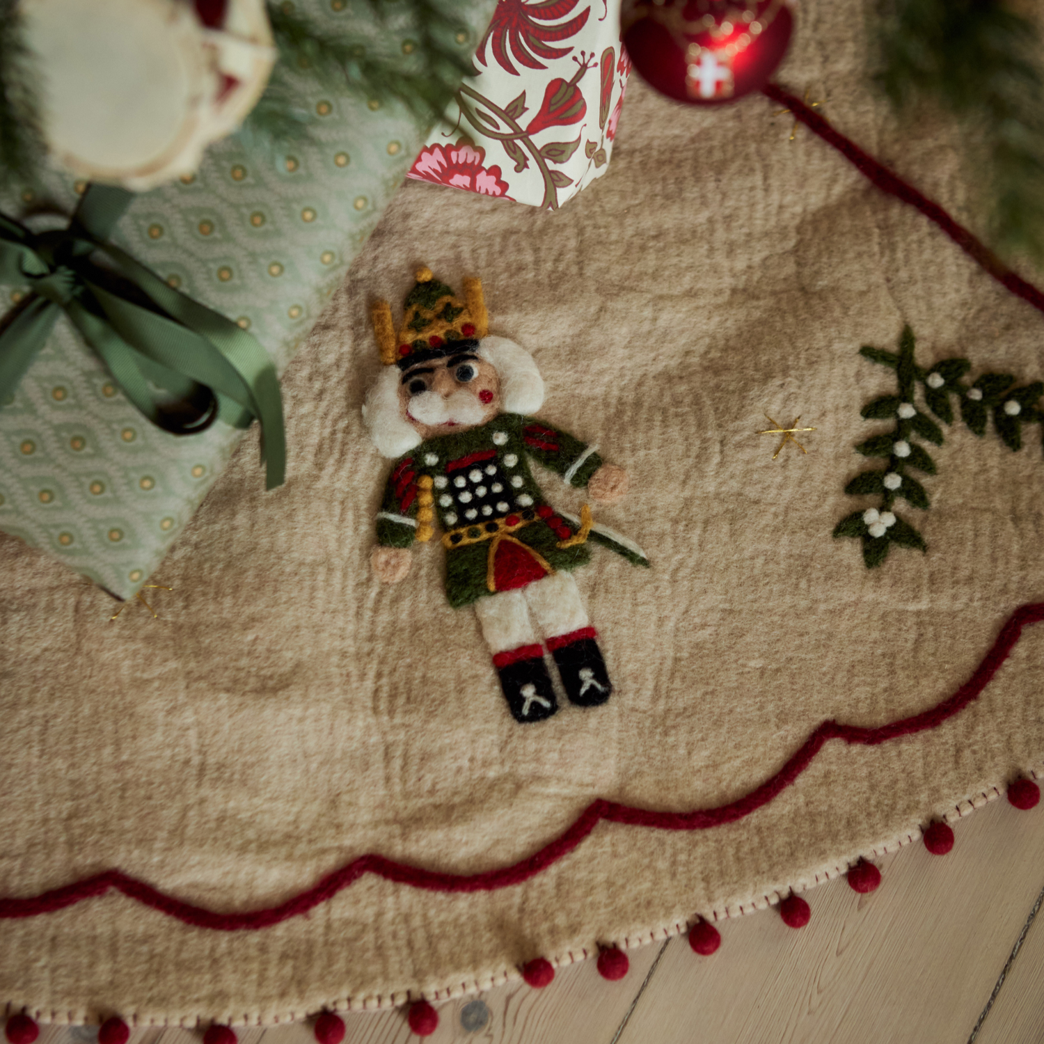 Close-up of Nutcracker Heirloom Tree Rug showing intricate details, with additional festive decorations nearby