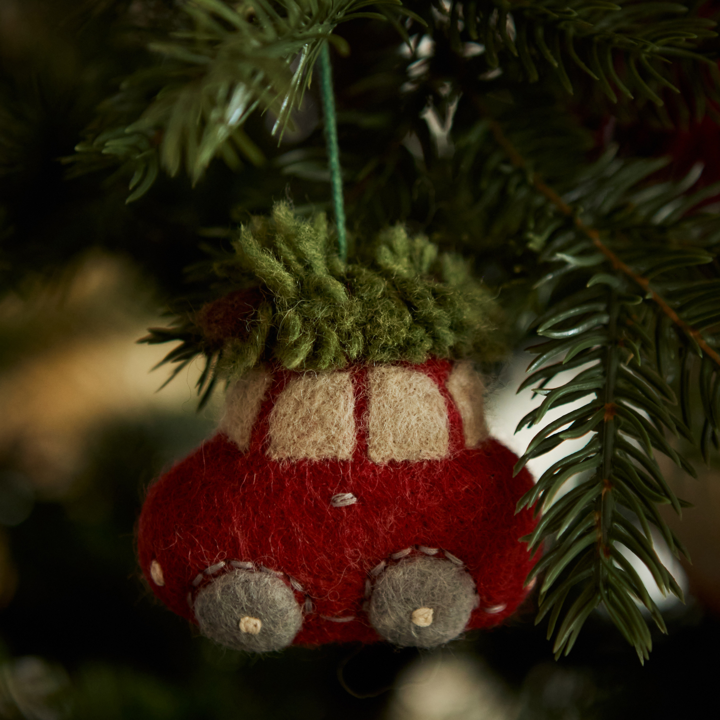 Car Ornament featuring a vintage car with a Christmas tree on top, hanging on a Christmas tree