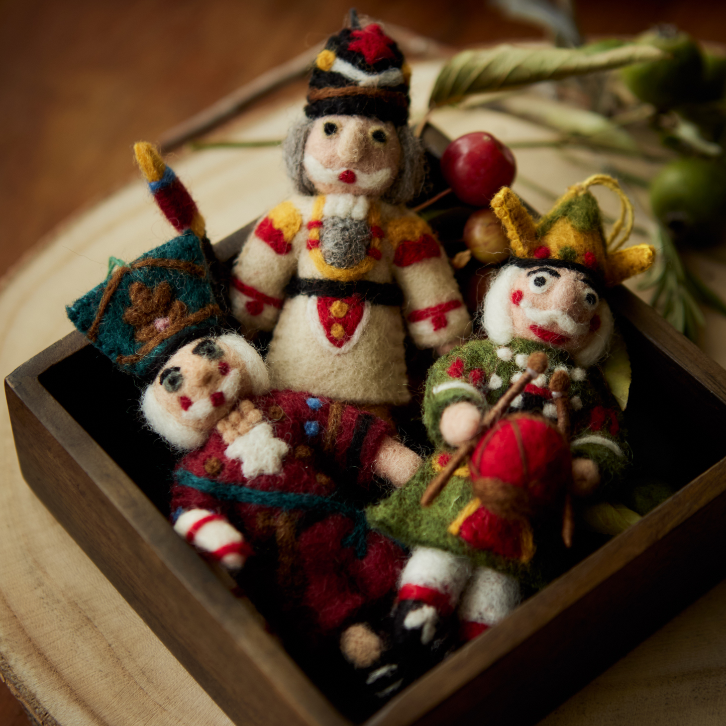 Various Nutcracker ornaments in red, cream, and green displayed together in a box