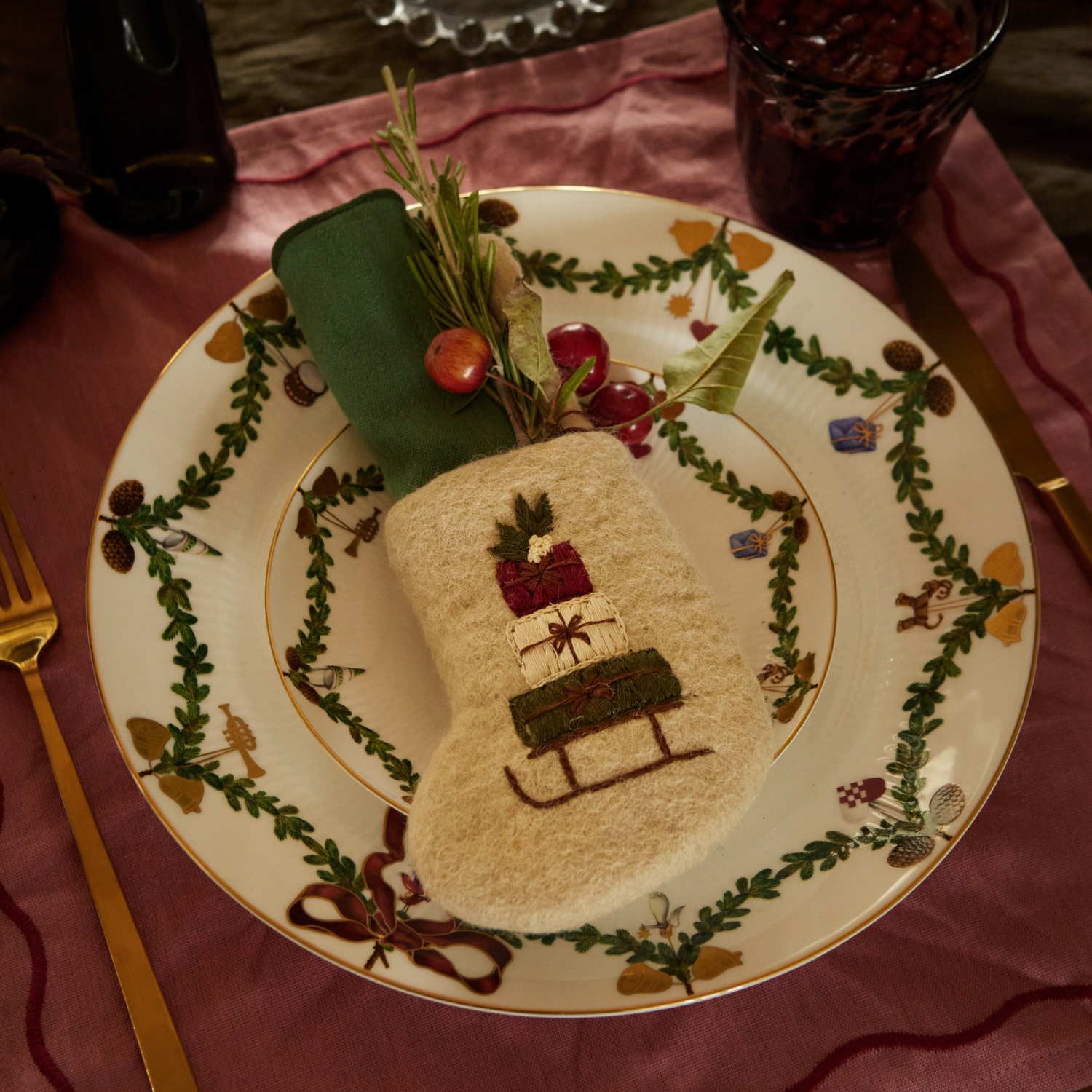 Mini Stocking Sleigh displayed on a decorative plate, showcasing its intricate embroidery and festive design against an elegant background.