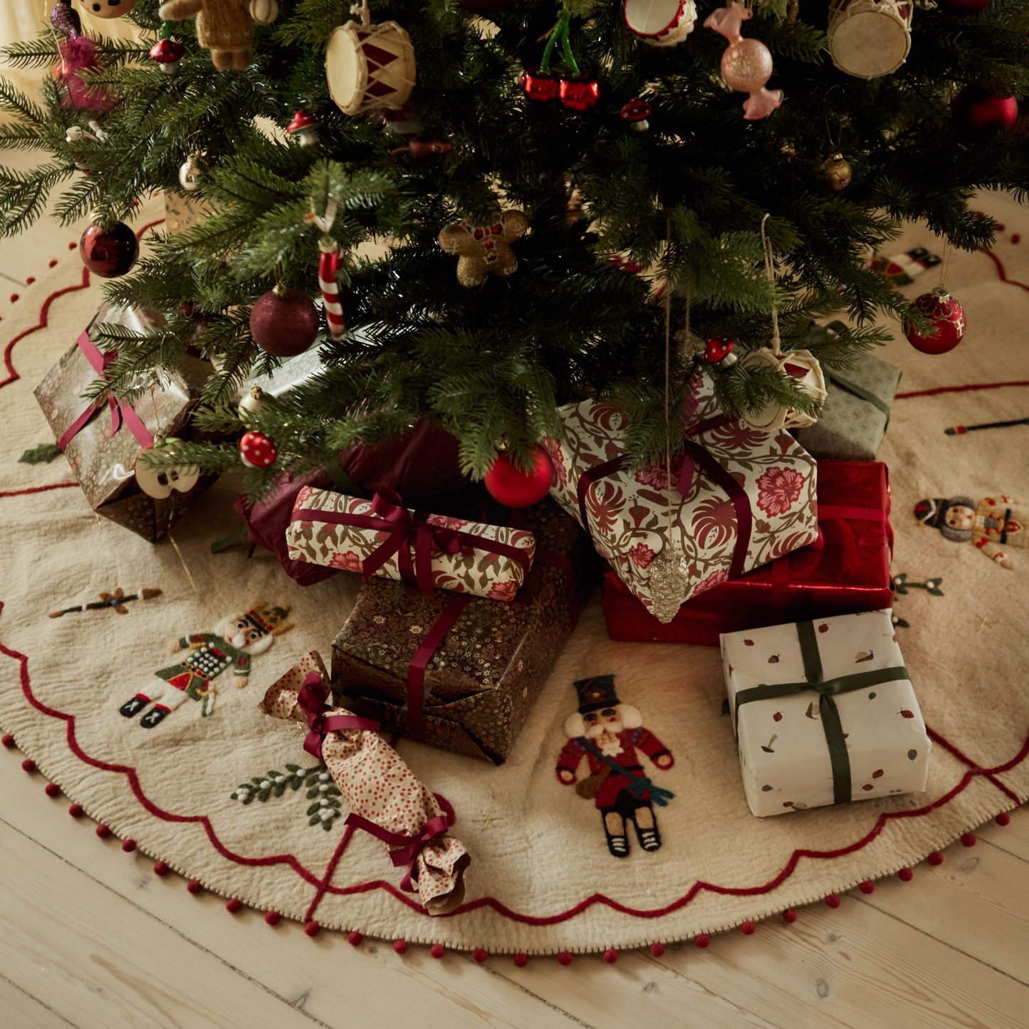 Nutcracker Heirloom Tree Rug under a Christmas tree with wrapped gifts placed on it