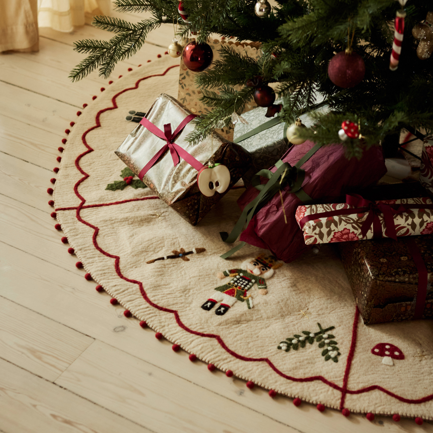 Nutcracker Heirloom Tree Rug under a Christmas tree with beautifully wrapped gifts placed on it, highlighting its festive charm.