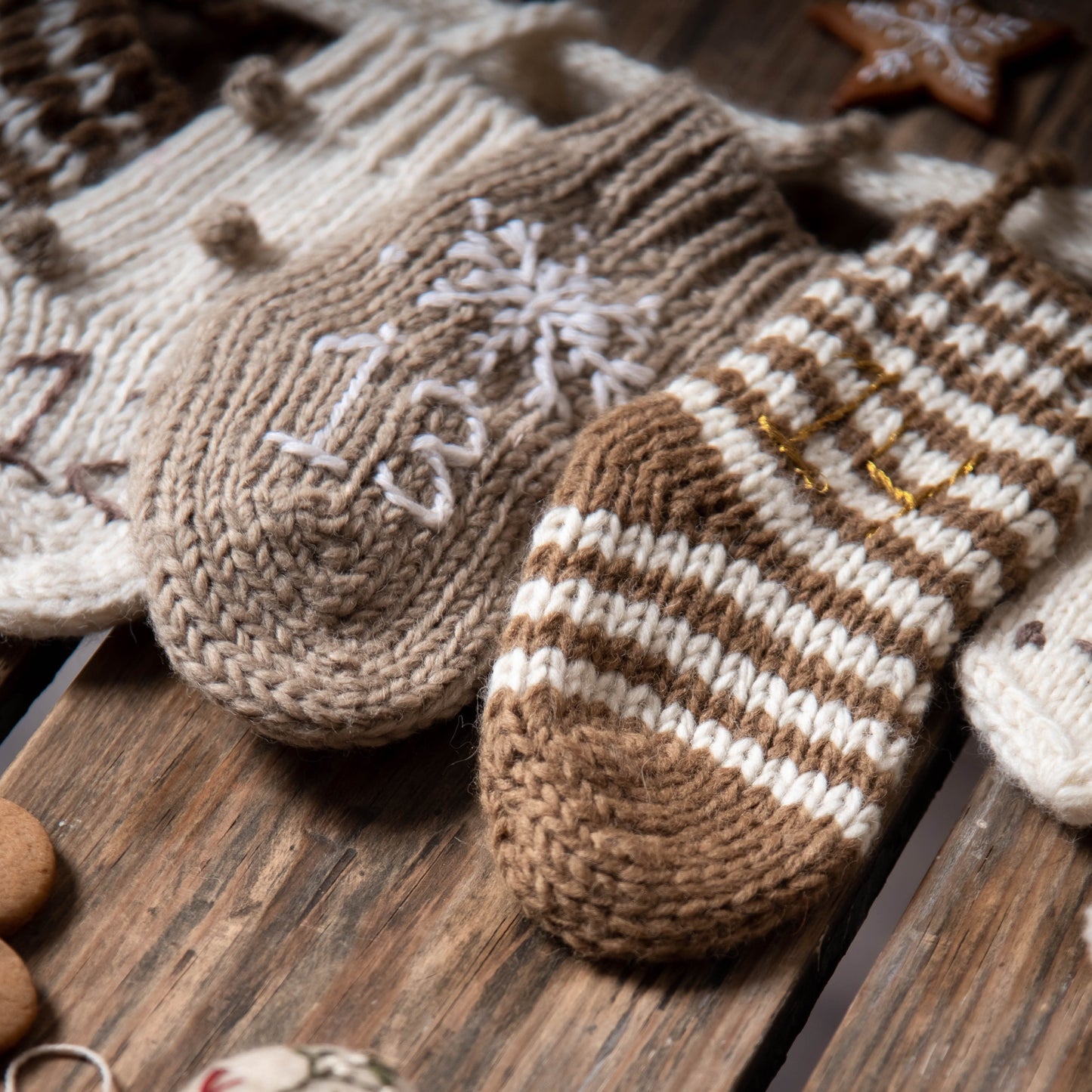  Close-up of three gray socks from the cream wool Advent Calendar, showcasing their handcrafted details and embroidered numbers.