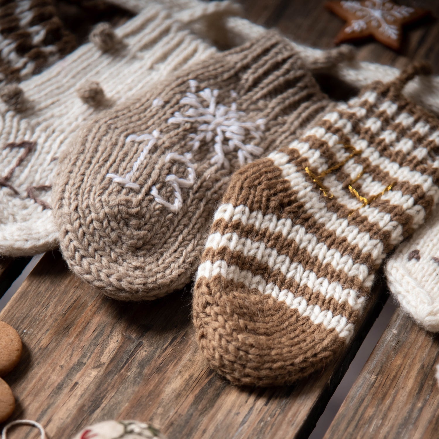  Close-up of three gray socks from the cream wool Advent Calendar, showcasing their handcrafted details and embroidered numbers.