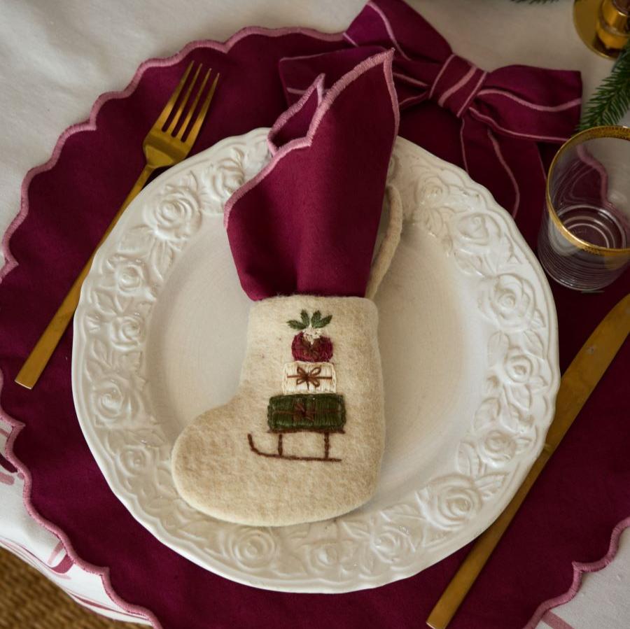 Mini Stocking Sleigh on a decorative plate with a small item or treat inside, capturing the festive embroidery and detailed design against a stylish backdrop.