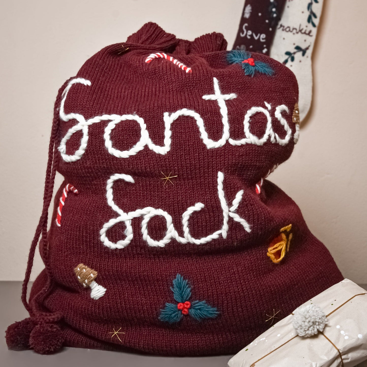 Red wool Santa sack with "Santa's Sack" embroidered, centered in the frame.