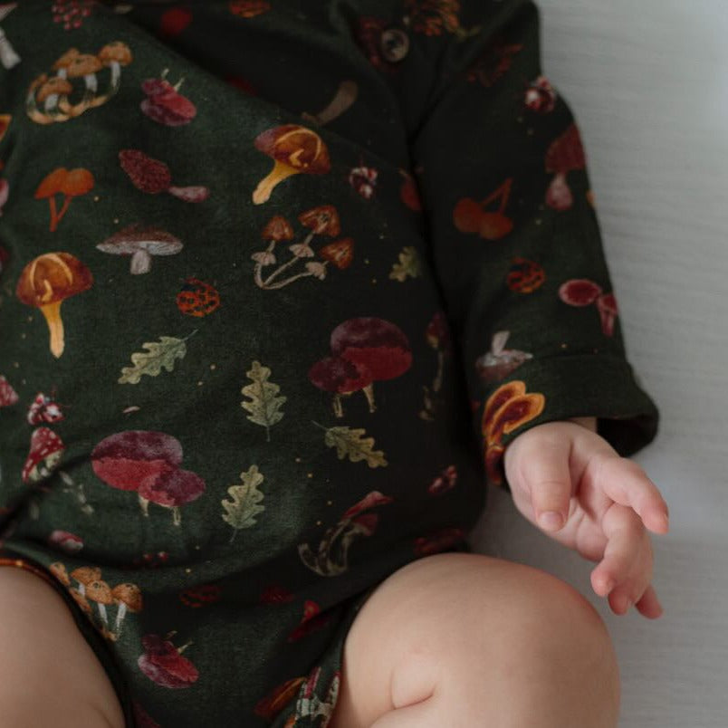 A close-up of the mushroom-print fabric on the baby’s sleeve and torso.
