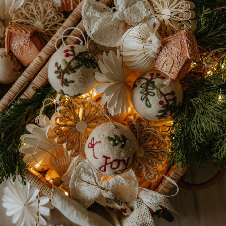 Multiple Bauble Joy Ornaments arranged in decorative boxes, surrounded by other festive decorations, emphasizing their intricate designs and holiday appeal.